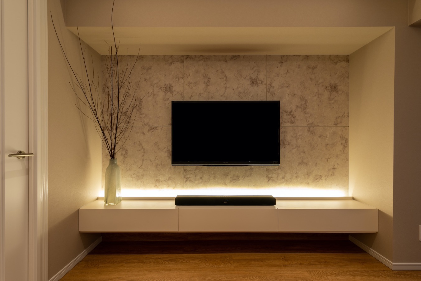 テレビコーナーは石目調のパネルとテレビボードの照明でシックで洗練された仕上がりに。