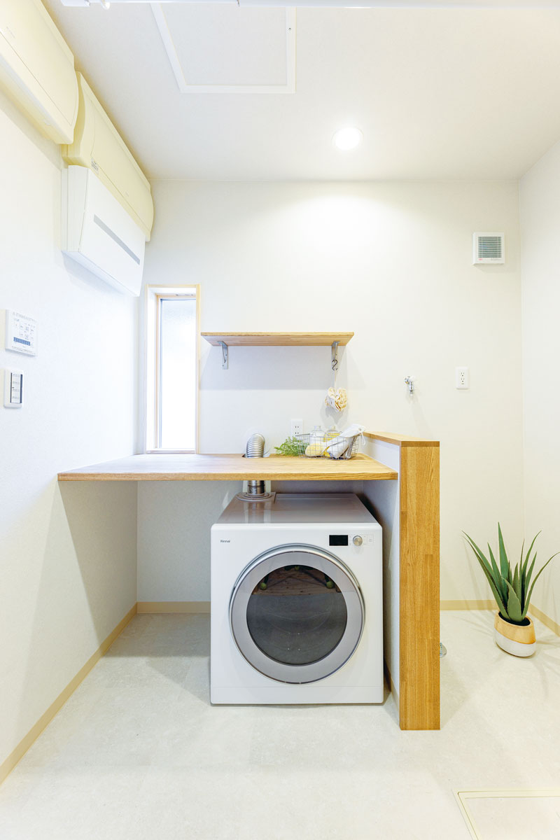 洗面台があった場所に洗濯物を畳むカウンターテーブルとガス乾燥機を設置