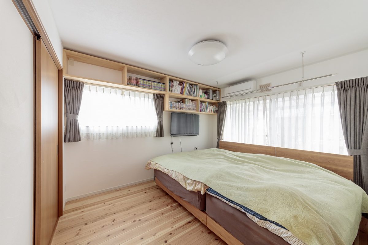 家族4人で寝られる広めの寝室。壁には本棚を造りつけて空間を有効活用。