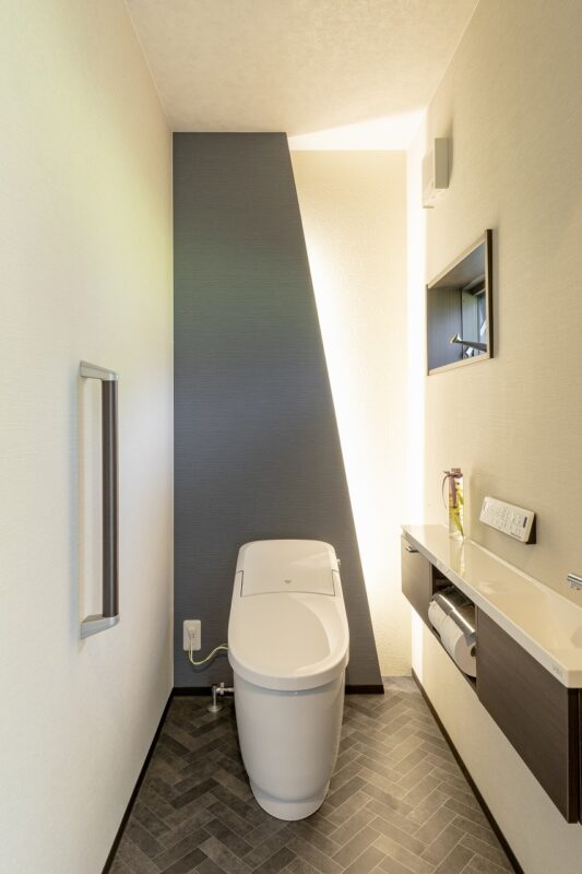 斜めにカットした壁に設置した間接照明が格好いいと、ゲストにも好評なトイレ。