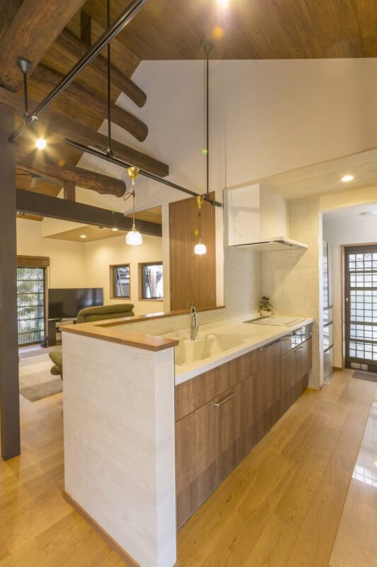 対面式にしたキッチンは部屋になじむ木目調のパネルにタイルでアクセントを。