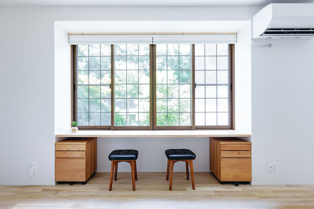 明るい出窓の前には、床と同じ色調の丈夫な集成材で、カウンターデスクを造作