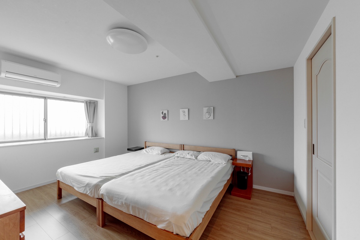 主寝室は薄いグレーのアクセントクロスとカーテンを採用し、落ち着いた部屋に一新。