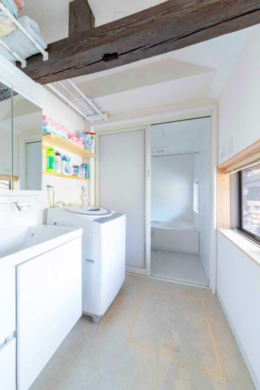 白く清潔感のある洗面室。梁は収納棚の設置に利用しました
