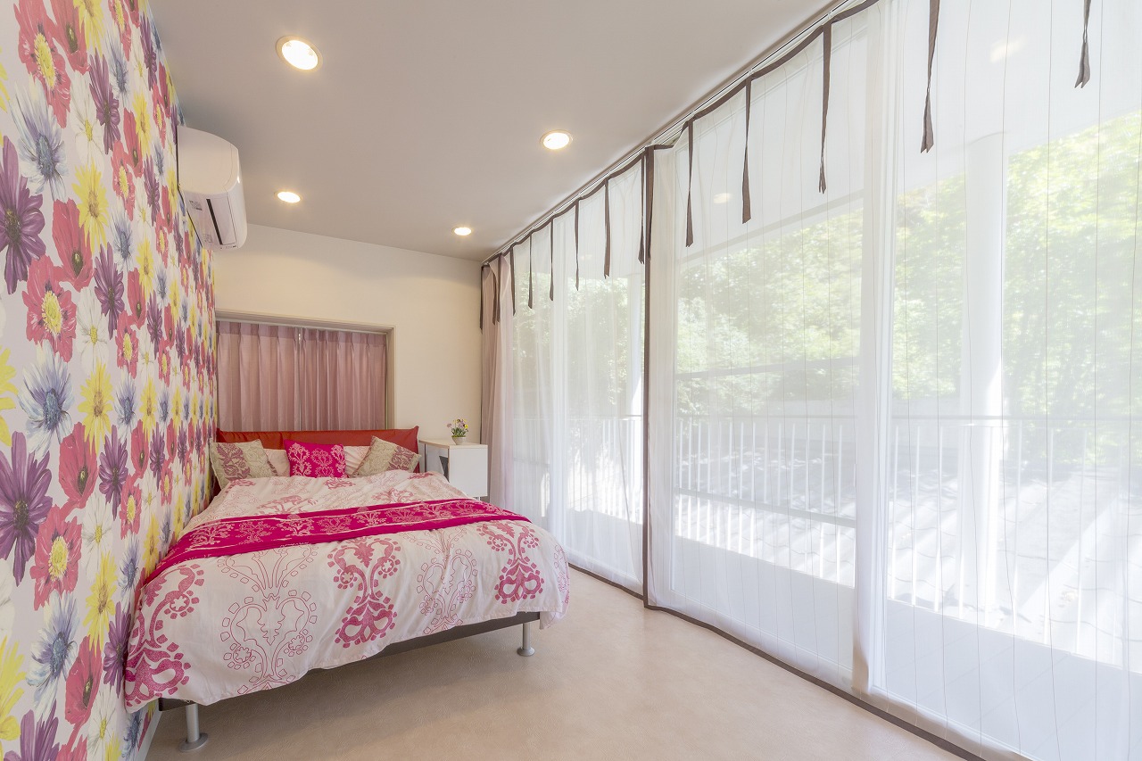 畳敷きの和室をフロアタイルにした寝室。鮮やかな花柄のアクセントクロスは奥さまのお気に入り。