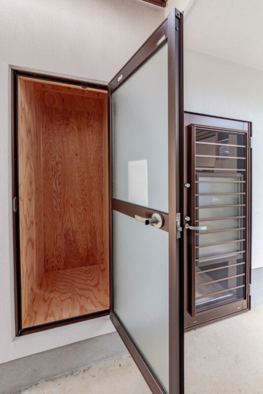 勝手口の隣に宅配ボックスを設置。元の裏口に使われていたドアを再利用。