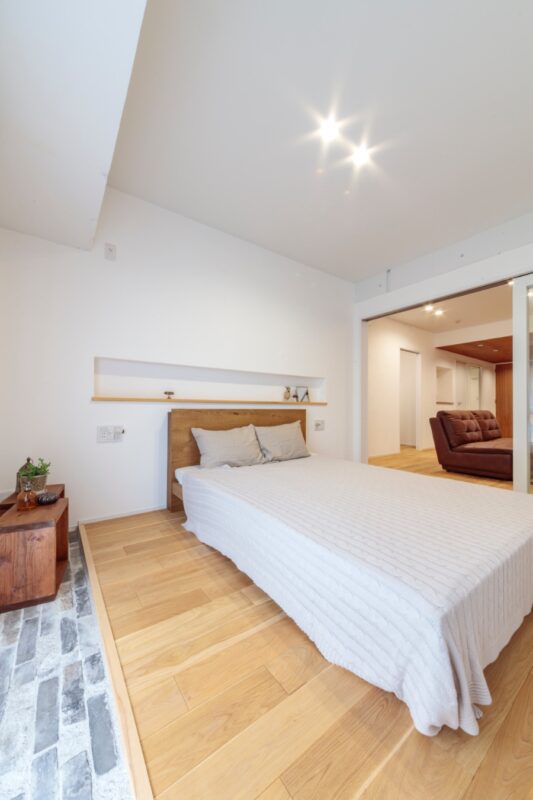 室内の床の高さをそろえたことで生じた寝室の段差は、フロアタイルを敷き空間のアクセントに活用。