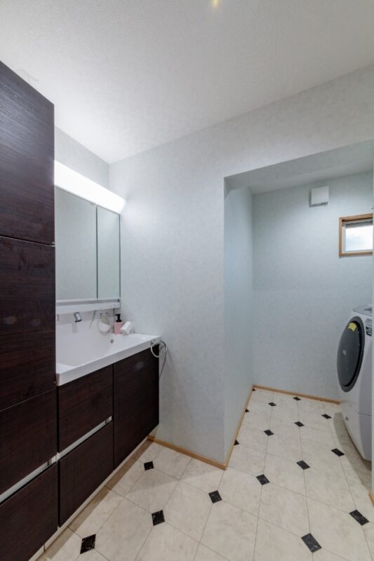 変形の空間をうまく活用した洗面室。床はタイル調のクッションフロアを選択。