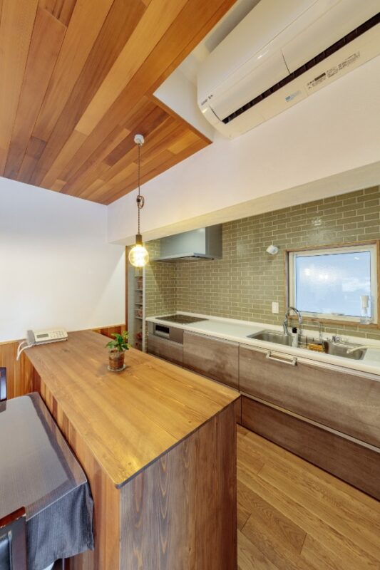 壁向きキッチンの前面に貼ったタイルが、部屋の美しいインテリアに。