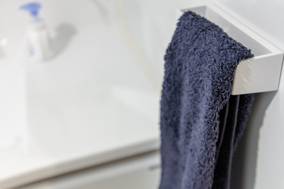洗面台の側面はお手入れの簡単なホーローパネル。マグネット式のタオルハンガーは好きな場所に設置できて便利。