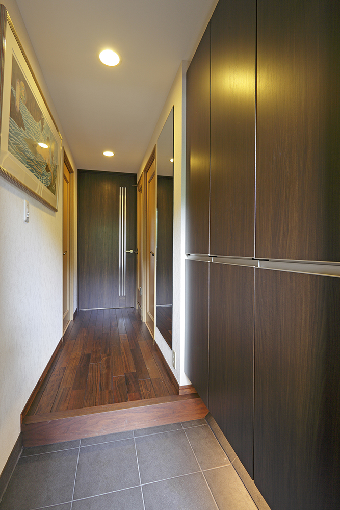廊下は銘木の無垢板、扉は2350mmのハイドアを採用した風格ある玄関。