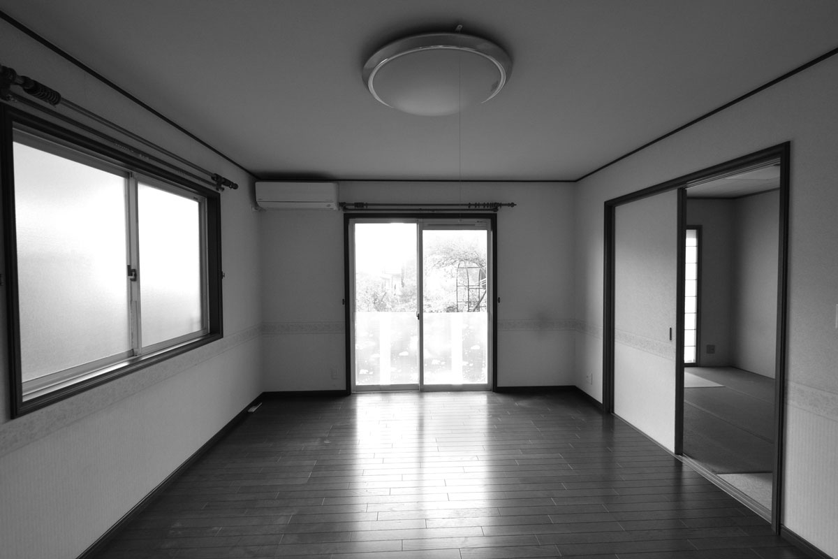 リビングは濃い色の床材とアイボリーのクロスでまとめた洋室でした